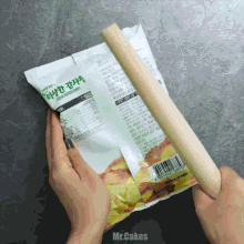 a person is holding a bag of potato chips that says mr.cakes on the bottom