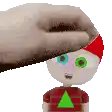 a hand is touching a cartoon character 's head with a green triangle on his shirt .