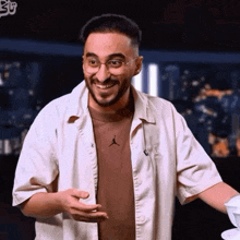 a man with glasses and a beard is smiling and holding a bowl .