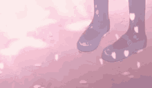 a person is standing on a pink tiled floor with cherry blossom petals falling on the ground .