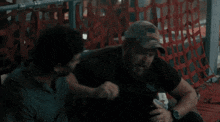 a man in an american flag hat is talking to another man