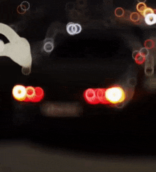a blurry picture of a car 's tail lights with a license plate that says ' aa ' on it