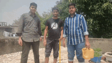a man wearing an avengers shirt is standing with two other men