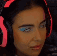 a woman is wearing headphones and making a funny face .