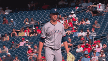 a texas baseball player stands in front of a crowd of people