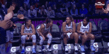 a group of uconn basketball players are sitting on the bench