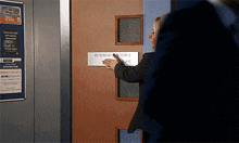 a woman is standing in front of a door that says interview room 2 on it
