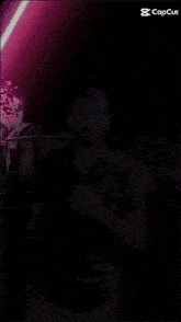 a man is standing in front of a purple light that says capcut on the bottom right