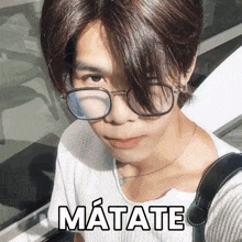 a man wearing glasses and a white shirt has matate written on his face