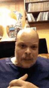 a bald man with a beard and mustache is giving a thumbs up sign
