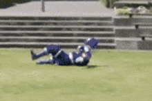 a person is laying on their back on the grass in front of stairs .