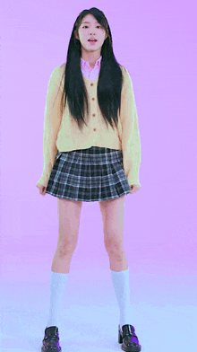 a girl in a plaid skirt and a yellow sweater is jumping in the air