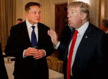elon musk and donald trump are standing next to each other and talking in a room .