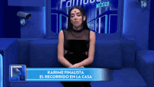 a woman is sitting on a couch with a banner that says karime finalista el recorrido en la casa