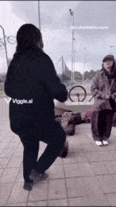 a woman is dancing in front of a man with a bicycle on the ground