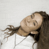 a woman wearing a white shirt and a silver chain necklace