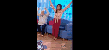 a man and a woman are sitting on a couch while dancing .