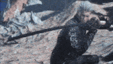 a man with gray hair is holding a large black sword