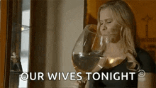 a woman is drinking from a very large glass of wine .