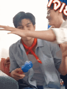 a man with a bandana around his neck holds a blue balloon with the word pepsi on it