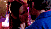 a man and a woman are kissing in front of a red white and blue background