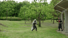 a man in a black and red costume is standing in a park