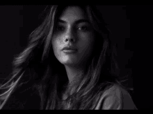 a black and white photo of a woman 's face with long hair