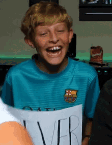 a young boy wearing a barcelona shirt is laughing