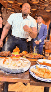 a man is standing in front of a table with plates of food