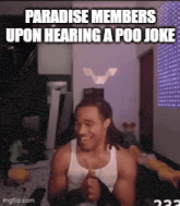 a man in a white tank top is laughing while hearing a poo joke