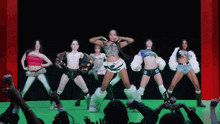 a group of women are dancing in front of a crowd with one wearing a shirt that says ' monster ' on it
