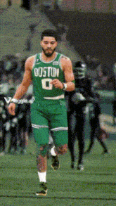 a man in a green boston jersey is running on the field
