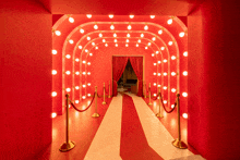 a red and white striped carpeted hallway with a red curtain and lights