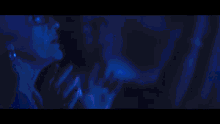a man singing into a microphone in front of a blue backdrop