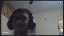 a man wearing headphones is on a video call with the name samay s