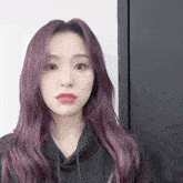 a woman with long purple hair has a heart on her face
