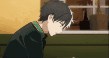 a boy with black hair and white hair is looking down