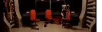 a person in a mascot costume is standing in a room with chairs and a clock .