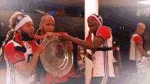 a group of soccer players holding a trophy with the number 7 on their jersey