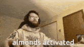 a man with a beard and headphones is playing a keyboard and says almonds activated