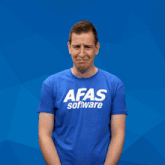 a man wearing a blue afas software t-shirt making a funny face