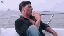 a man is smoking a cigarette on a boat .