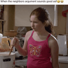 a girl in a pink tank top with a butterfly on it stirs a pot