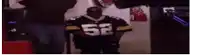 a man is wearing a football jersey with the number 52 on it .