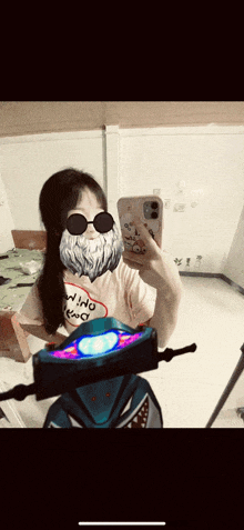 a girl wearing sunglasses and a beard takes a selfie