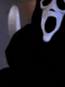 a close up of a person wearing a scream mask with their mouth wide open .