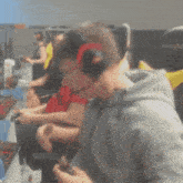 a man wearing headphones is playing a video game in a room with other people