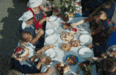 a group of people are sitting around a table with plates of food on it