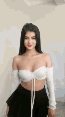 the girl is wearing a white off the shoulder top and a black skirt