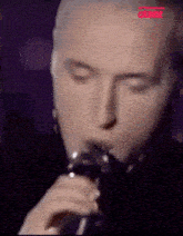 a close up of a man singing into a microphone with the word crime on the bottom right